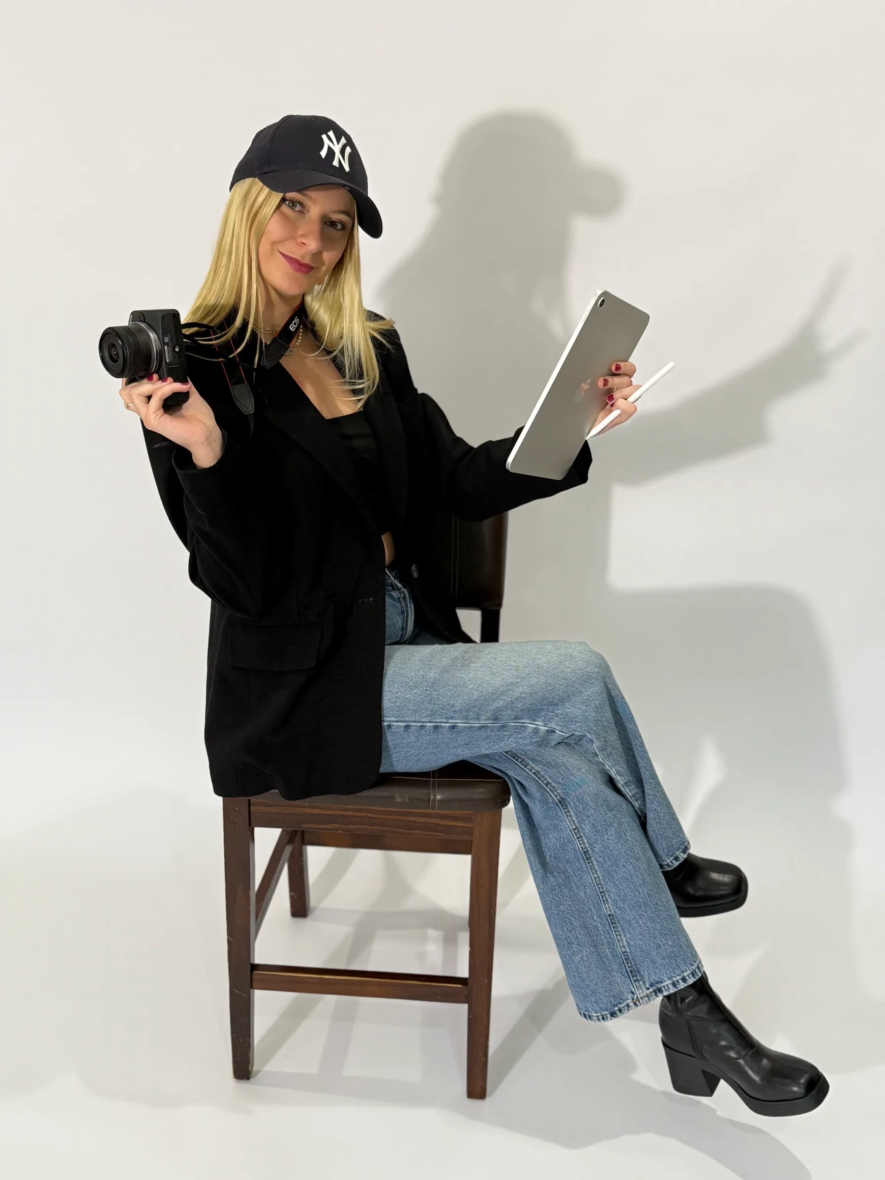 Fanny assise en studio avec un appareil photo et une tablette