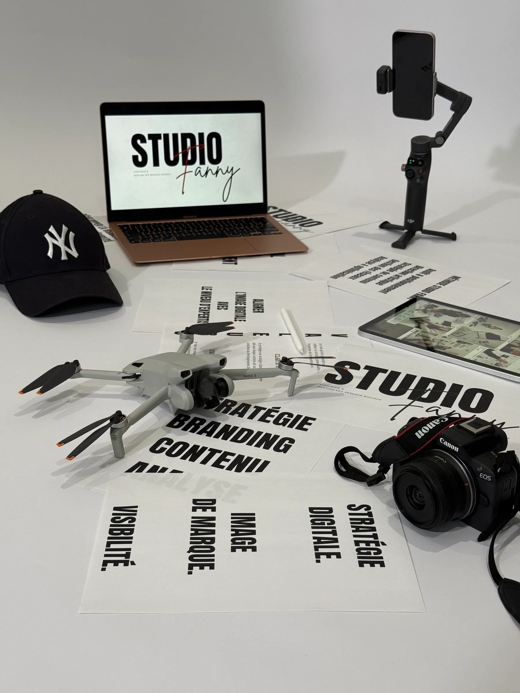 Le matériel de Studio Fanny : drone, appareil photo, stabilisateur, ordinateur et tablette posés sur les supports de stratégie